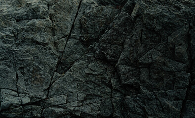 Black stone background. Dark rock surface texture at coast near the sea. Abstract pattern. Natural backdrop. Natural rock surface. Element, material design.