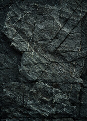 Black stone background. Dark rock surface texture at coast near the sea. Abstract pattern. Natural backdrop. Natural rock surface. Element, material design.Vertical.