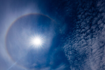 A captivating image of a sun halo against a deep blue sky, created by the refraction of sunlight...