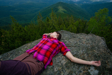 Naklejka premium Woman in pink shirt on the rock in Carpathian mountains