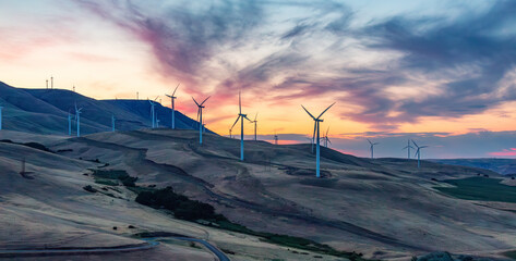 Wind Turbines on a Windy Hill during a colorful sunrise.