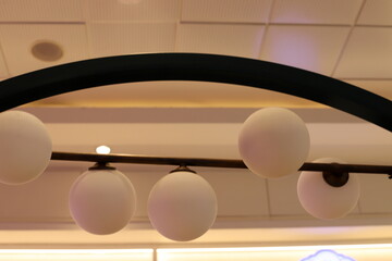 A lamp for illuminating the interior of the room hangs on the ceiling.