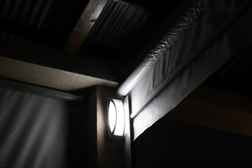 A lamp for illuminating the interior of the room hangs on the ceiling.