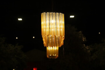 A lamp for illuminating the interior of the room hangs on the ceiling.