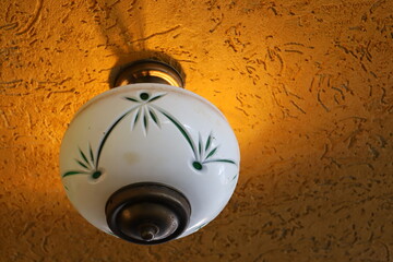 A lamp for illuminating the interior of the room hangs on the ceiling.