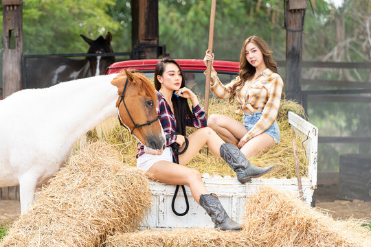 Young adult Asian woman fashion in natural environment. woman enjoying hug a horse in countryside.