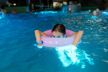 Closeup portrait of little swimmer girl take a rest after swimming in the swimming pool. Little...
