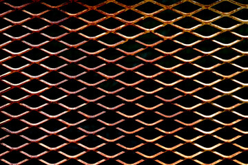 Empty black perforated rust metal grid with diamond holes for abstract rusty metallic mesh plate background, rust steel mesh texture. seamless patterns, space for work, vintage wallpaper,close up.