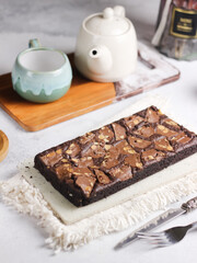 Chocolate brownies squares with chocolate chips and walnuts slices on top. Freshly baked brownies. Best fudgy brownies cakes. Selective focus with shiny and rough texture
