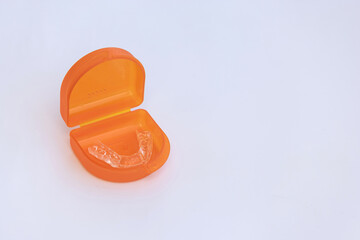 A splint for teeth to align the jaw in a storage box on a white background