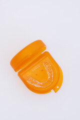 A splint for teeth to align the jaw in a storage box on a white background