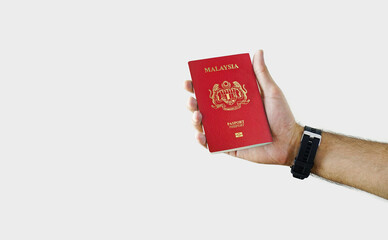 Man holding Malaysia Passport in hand on white background with copy space - Malaysian
