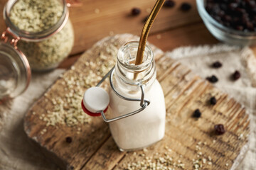 Vegan hemp seed milk in a glass bottle with an ecological stainless steel straw