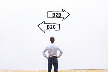 B2B vs B2C concept, business marketing strategy, businessman looking at arrows on white wall
