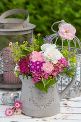 florales Arrangement mit Blumenstrauß mit Rosen, Hortensienblüten, Bartnelke und Frauenmantel im vintage Krug © Natalia Greeske