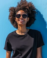 Smiling woman in a black t-shirt with a blue background