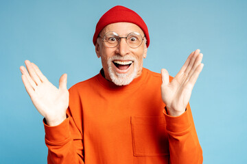 Naklejka premium Happy smiling senior man spreading his arms to sides, rejoicing, isolated