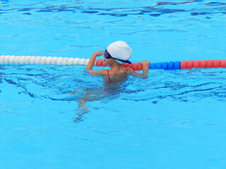 A young girl is swimming in a pool 