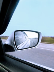 Fototapeta premium mirror view from the window of a gray car moving on the road to the front car mirror and road movement speed track trip road trip 