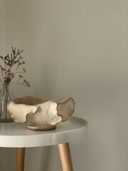 Cozy vintage paper mache plate, vase on a wooden table with dry wild flowers, white background,...