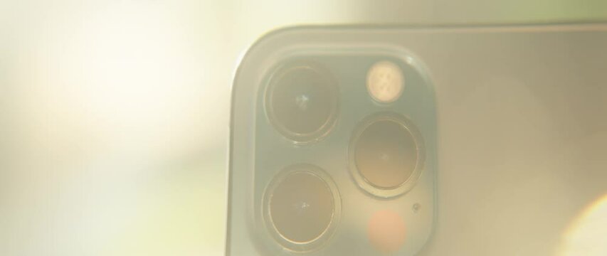 Macro shot with tilt-shift lens on the triple-lens camera on smartphone. Colourful light. Moving around