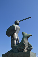 Statue of Mermaid (Polish: Warszawska Syrenka) symbol of Warsaw by the Vistula river. Closeup view with blue sky background © PaulSat