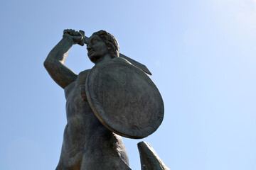 Statue of Mermaid (Polish: Warszawska Syrenka) symbol of Warsaw by the Vistula river. Closeup view with blue sky background © PaulSat