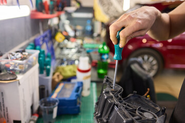 showing hands effectively repairing a car headlight in a workshop environment