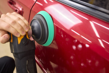 Person using machine to polish cars automotive exterior