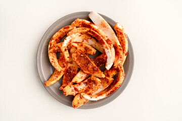 gray plate with slices of coconut with chili salt and lemon on white background