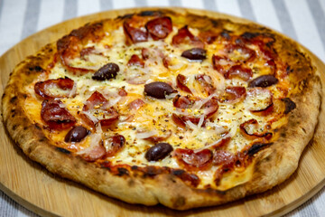 Calabrian sausage pizza served on a round board and set table