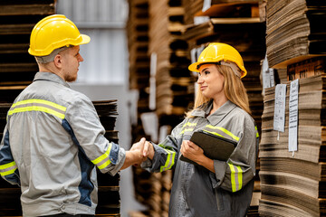 man and woman worker walking and checking stock for shipping. Female inspecting the store factory. Logistics employees holding folders at on site warehouse area for shipping transportation.