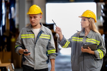 man and woman worker walking and checking stock for shipping. Female inspecting the store factory. Logistics employees holding folders at on site warehouse area for shipping transportation.