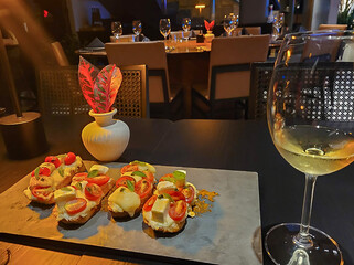Table set on a rustic surface and crystal glass, gorumet antipasto served