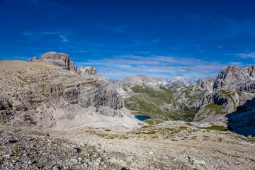 Dolomites, Alpi Dolomiti beautiful scenic mountain landscape under blue sky in summer. Rocky tower peak summits of the Alps on a sunny day. Alpine scenic view of the cliffs and climbing walls in Italy