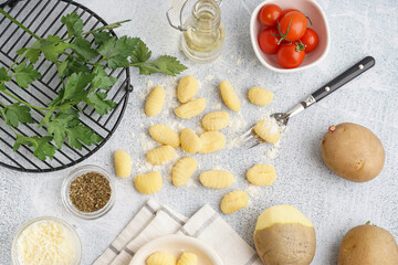 Composition with tasty gnocchi, tomatoes, parsley and potatoes on light background