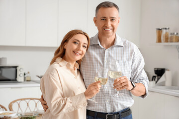 Mature couple with glasses of wine in kitchen