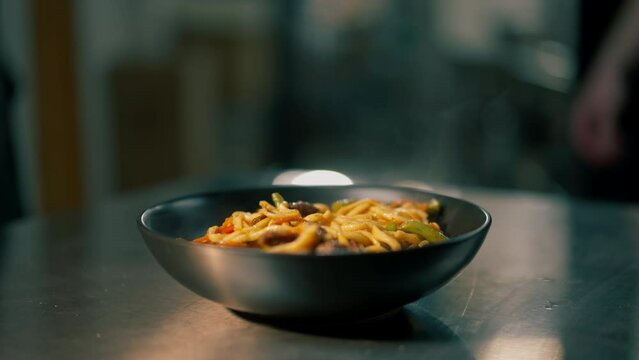 close-up in professional kitchen there is black whiskey with vog noodles on the table