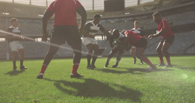 Image of glowing lights over diverse rugby players in sports stadium