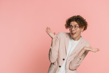 What. Why. Angry confused young man with curly hair raising hands in indignant expression, asking...