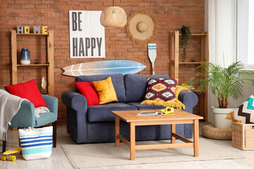 Stylish interior of living room with surfboard on brick wall