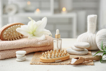 Beautiful composition with massage body brushes, spa stones and scoop of sea salt on table, closeup
