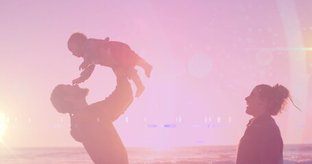 Image of light spots over happy caucasian couple with baby at beach