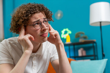 Displeased man wearing eyeglasses rubbing temple to cure headache problem, suffering from tension...
