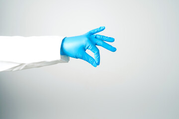 Doctor or nurse hand in sterile gloves in holding position isolated on white