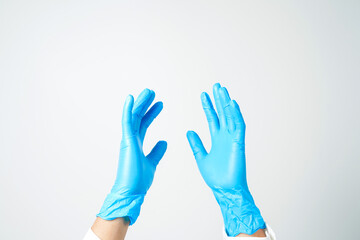 Doctor's hand in blue medical gloves holding an object on a white background