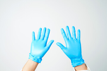 Doctor's hand in blue medical gloves holding an object on a white background