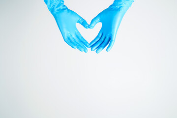 Human rising hands make finger heart shape wearing blue surgical glove, isolated