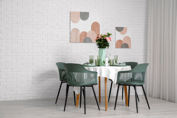 Beautiful table setting for wedding with flowers near white brick wall in dining room