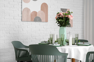 Beautiful table setting for wedding with flowers near white brick wall in dining room